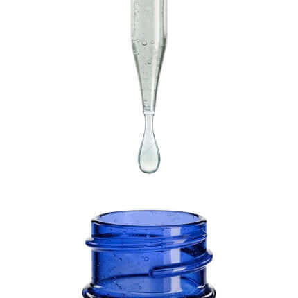Clear dropper dispensing a drop into a blue bottle, highlighting purity in fitness and nutrition products.